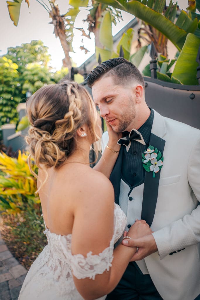 Bride and Groom kissing against fence at wedding in St. Pete