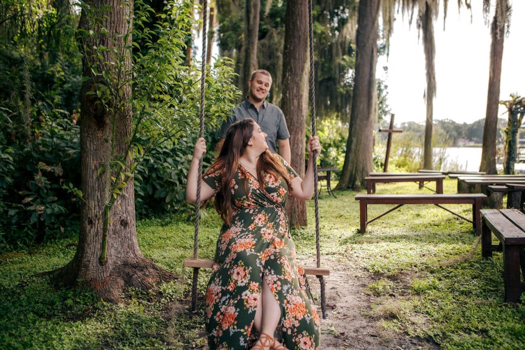 Engaged couple on swing at Knotted Roots on the Lake