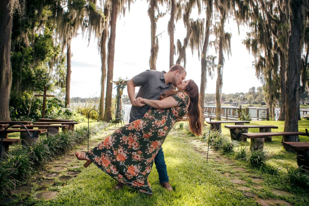 Engaged couple dipping in aisle at Knotted Roots on the Lake